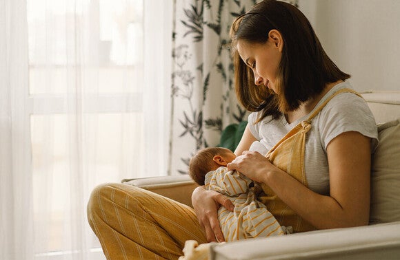 Mama karmiąca niemowlę piersią w pozycji siedzącej – codzienność w 4. trymestrze ciąży