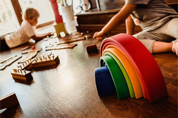 Tęcza Montessori i cylindry Montessori leżące na podłodze podczas zabawy dzieci Tęcza Montessori i cylindry Montessori leżące na podłodze podczas zabawy dzieci