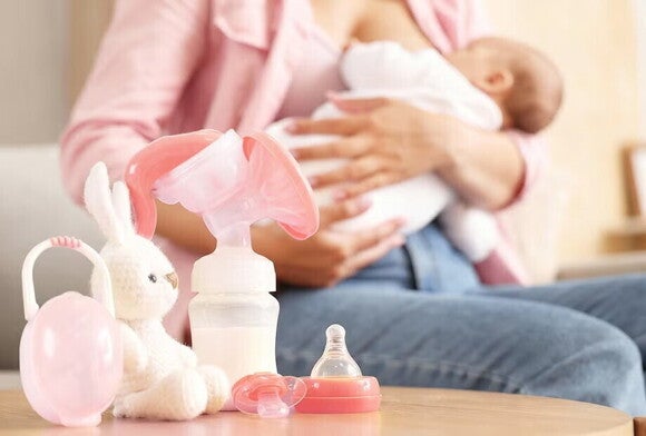 Mama karmiąca piersią i odciągająca pokarm za pomocą laktatora