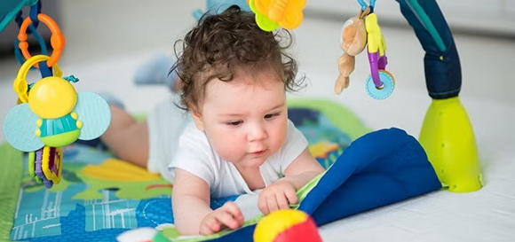 Niemowlę podczas zabawy na macie Niemowlę podczas zabawy na macie