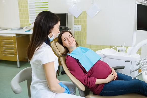 kobieta w ciąży u dentysty Jeśli masz ubytki, najlepiej wylecz je jeszcze przed ciążą. W I trymestrze wskazana jest szczególna ostrożność w stosowaniu leków przeciwbólowych, przeciwzapalnych i środków znieczulających. Należy wówczas unikać zabiegów stomatologicznych, ograniczając je do sytuacji absolutnie koniecznych – w I trymestrze ma bowiem miejsce najważniejszy etap kształtowania się płodu, zwany organogenezą. To w tym czasie tworzą się podstawowe narządy oraz układy Twojego maluszka. Warto również pamiętać, że w I trymestrze ciąży mogą nasilić się zmiany próchnicze. Przyczyną są: zwiększona liczba bakterii tworzących płytkę nazębną, obniżenie pH śliny i zmniejszenie jej ilości, nawracające nudności i wymioty – sok żołądkowy niszczy szkliwo i powoduje obniżenie pH w jamie ustnej, zwiększone łaknienie i ochota na produkty zawierające duże ilości węglowodanów. Również zmiany hormonalne związane z ciążą mogą wywoływać dolegliwości ze strony dziąseł. Wzrost stężenia estrogenów we krwi powoduje, że pod kobieta w ciąży u dentysty Jeśli masz ubytki, najlepiej wylecz je jeszcze przed ciążą. W I trymestrze wskazana jest szczególna ostrożność w stosowaniu leków przeciwbólowych, przeciwzapalnych i środków znieczulających. Należy wówczas unikać zabiegów stomatologicznych, ograniczając je do sytuacji absolutnie koniecznych – w I trymestrze ma bowiem miejsce najważniejszy etap kształtowania się płodu, zwany organogenezą. To w tym czasie tworzą się podstawowe narządy oraz układy Twojego maluszka. Warto również p