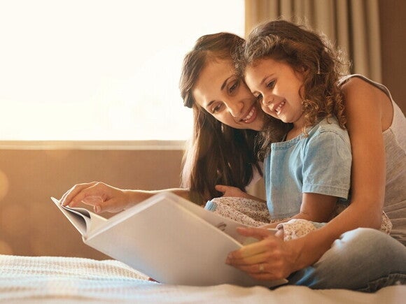 Dziewczynka czyta wspólnie z mamą książeczkę