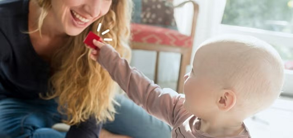 Zabawy dla niemowląt – dziecko podaje mamie czerwony klocek Zabawy dla niemowląt – dziecko podaje mamie czerwony klocek