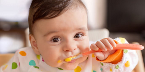 Baby eating with a spoon Baby eating with a spoon